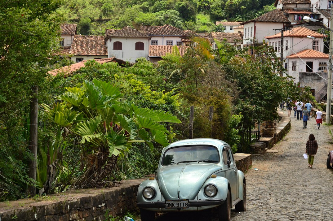 Cobblestone street in a historic colonial town with an old car