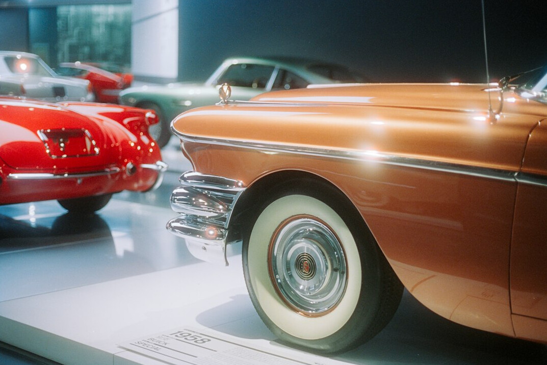 Automobile exhibition hall with dramatic spotlighting on classic cars