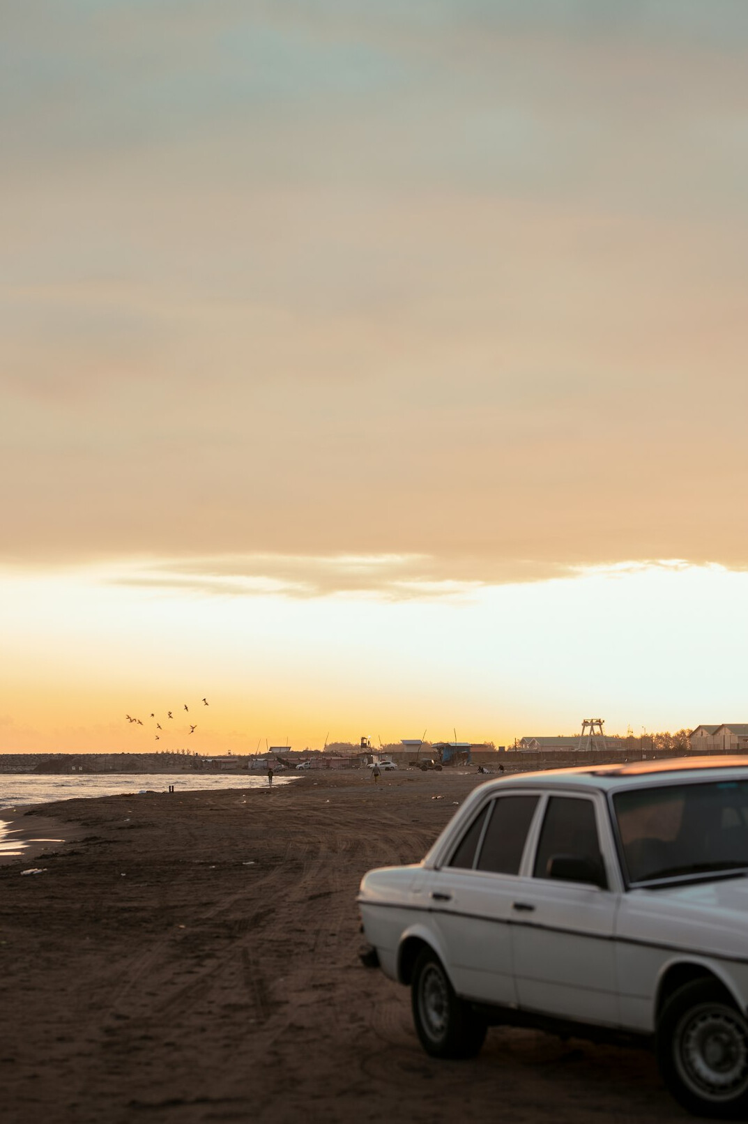 Luxury automobile parked near a sandy beach coastline