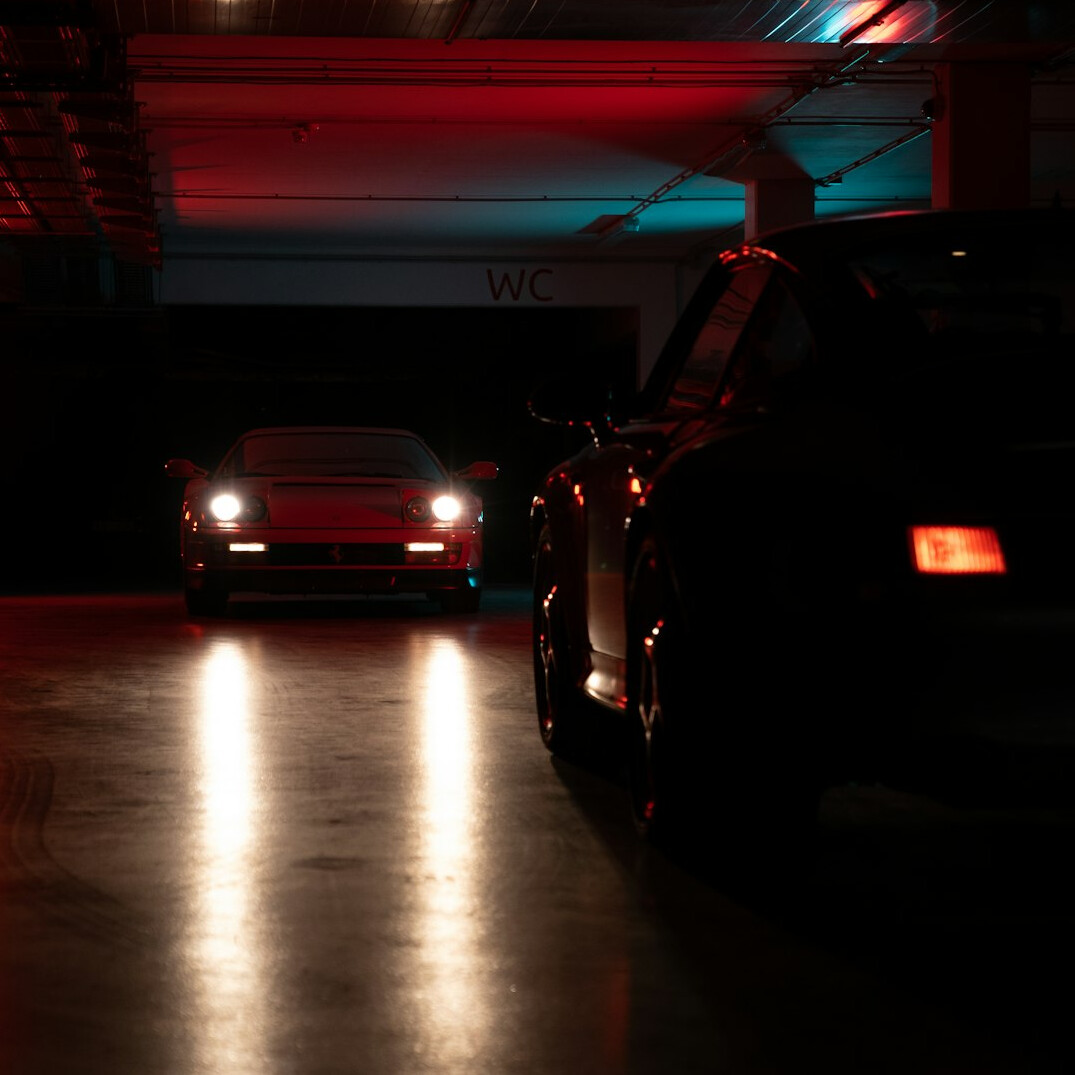 Private garage collection with several automobiles under moody lighting