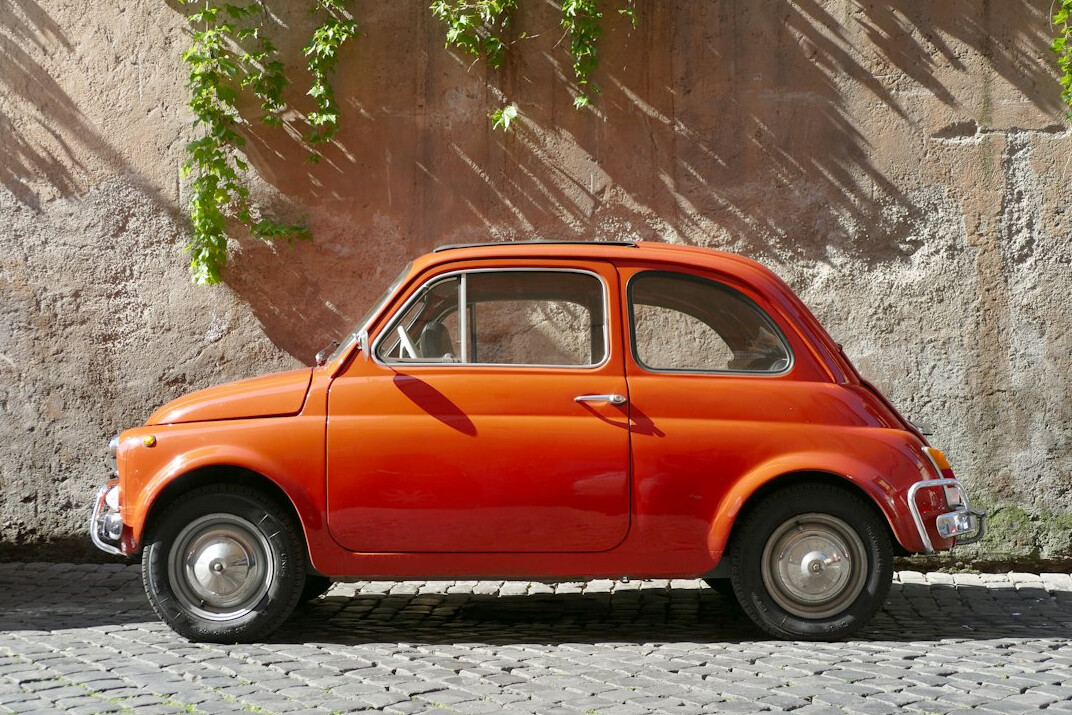 Red vintage Italian sports car parked on an open road
